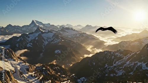A majestic eagle soars over a sun-drenched, snow-capped mountain range at sunrise.