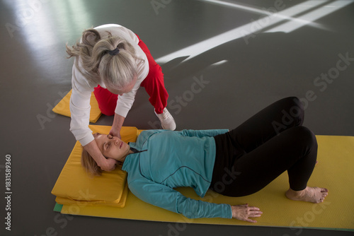 Senior woman trainer conducts somatic gymnastics for another woman in a gym. Somatic training - a sport for the anxious. reboot the nervous system. eliminating chronic muscle tension and increasing bo