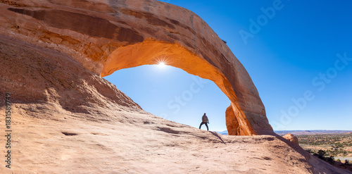 Wilson Arch is a natural sandstone arch in southeastern Utah, United States, just off U.S. Route 191 in San Juan County. It is located near the town of Page. Summer day with blue skies.