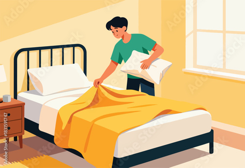 A person makes a bed with a pillow and yellow blanket in a room with a window, bedside table, lamp