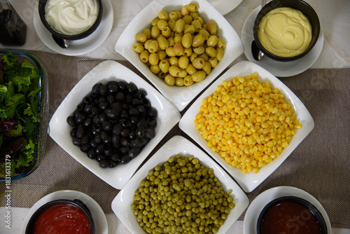 olives, green peas, corn with sauces on the buffet table