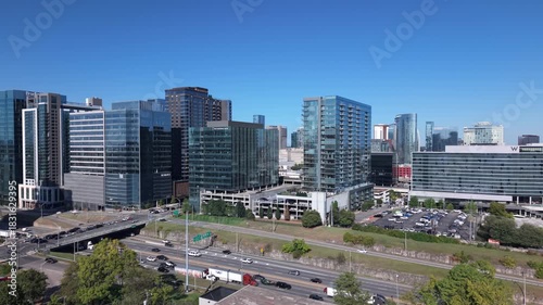 The modern skyline and bustling streets of The Gulch, Nashville, Tennessee in daytime ascending aerial reveal