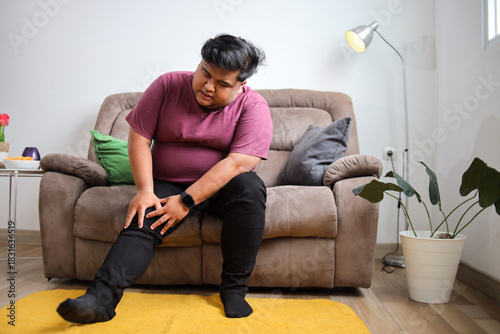 Man Experiencing Knee Pain While Relaxing at Home Seeking Relief and Comfort