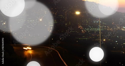 Camera focus shifting, bokeh discs appearing and drifting, cars moving curving bend, adding mood