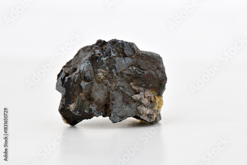 Принти на полотні Dark, irregularly shaped raw mineral, rock specimen, ore sample, isolated on a bright white background