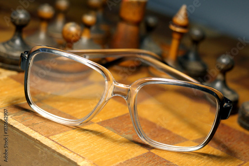 Old wooden chess set and glasses. Retro.