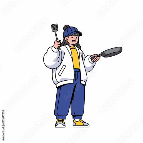 A Cheerful Young Woman Preparing Food with a Pan and Spatula in the Kitchen
