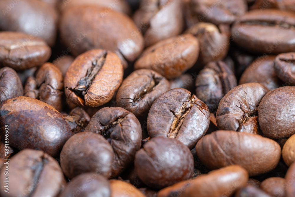 Naklejka premium Rich roasted bean imagery, Close examination of dark roasted coffee beans with shine, Highresolution macro photograph showcasing glossy roasted coffee beans in warm lighting