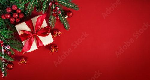 Merry Christmas holiday background. Red Christmas flat lay background with gift box, fir branches and holiday decorations.