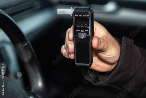 Obraz na plátně Male Hand Shows Digital Breathalyzer Inside A Car