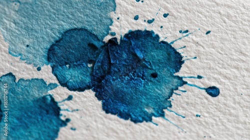 Dynamic blue watercolor stains forming organic splashes on paper