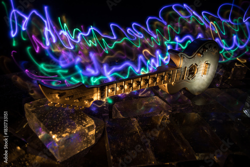 Music Concept: Guitar Miniature on a Dark Background with Vivid Light, Smoke, and Fire Effects. Golden electro guitar under a Dramatic Spotlight.