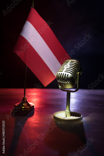 Microphone on a background of a blurry flag of Austria close-up. dark table decoration