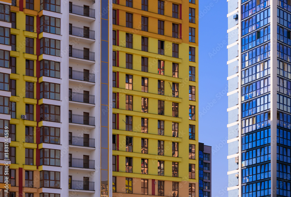 Obraz premium Cityscape on a summer day, modern buildings and houses against the blue sky 