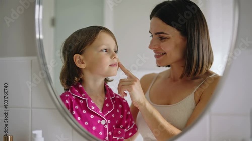 Mother and daughter doing skincare daily morning routine with face cream at home - Cosmetics, family and childhood concept - Models by AI generative