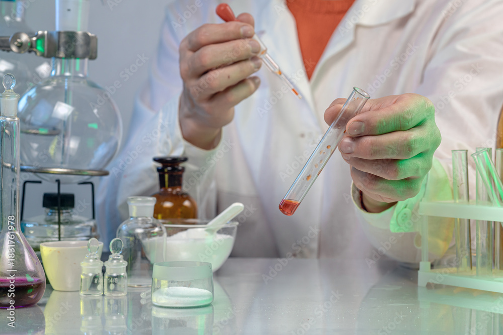 Fototapeta premium A scientist in a white coat works in a chemical laboratory