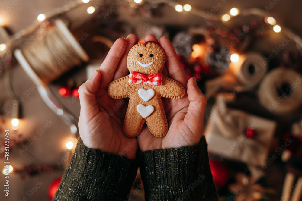 custom made wallpaper toronto digitalHand holding a cheerfully decorated gingerbread man cookie, with a colorful, warm Christmas backdrop