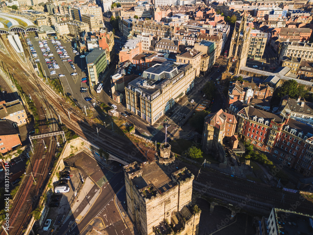 Obraz premium Newcastle upon Tyne: 17th Aug 2025: Aerial view showcasing Newcastle Castle, Central Station. The bustling city landscape features historic architecture, sunny morning