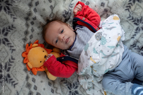 Newborn Lying on Cozy Blanket with Plush Toy