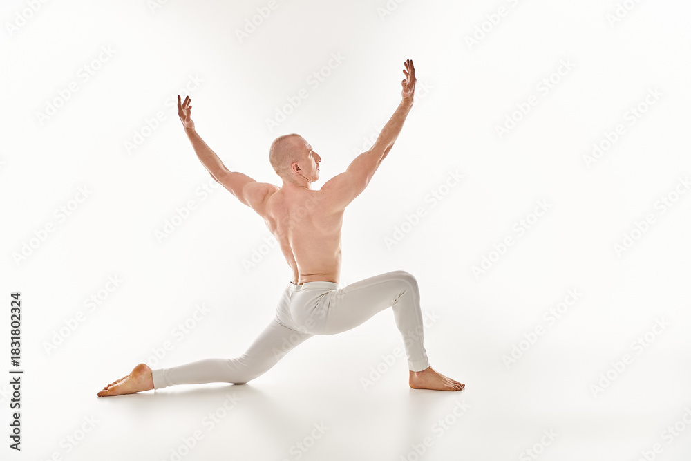 Fototapeta premium Stunning young athlete showcases vivid acrobatic pose in bright, minimalist setting