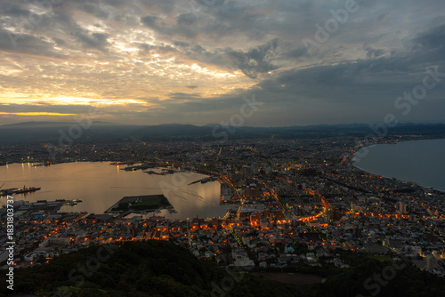 Dramatic sunset clouds and golden light illuminating the iconic cityscape of Hakodate, Hokkaido, viewed from Mount Hakodate.