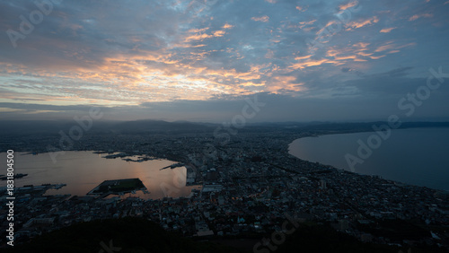 Dramatic sunset clouds and golden light illuminating the iconic cityscape of Hakodate, Hokkaido, viewed from Mount Hakodate.