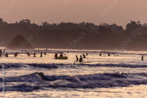 Photography Public town beach in Weligama at sunset with surfers, Sri Lanka