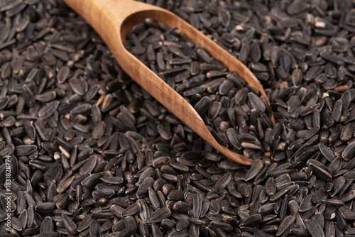 Fototapeta Naklejka Na Ścianę i Meble -  Bird food for street birds. small sunflower seeds with wooden scoop background texture. close up