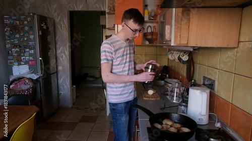 young man in the kitchen is preparing food for himself