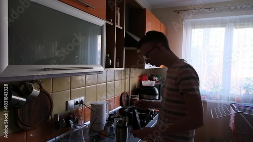 young man in the kitchen is preparing food for himself