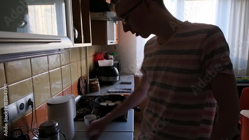 young man in the kitchen is preparing food for himself