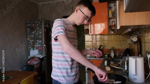 young man in the kitchen is preparing food for himself