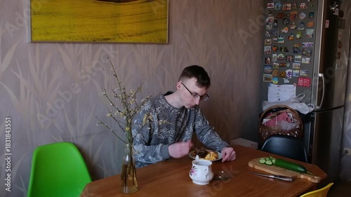 young man in the kitchen is preparing food for himself
