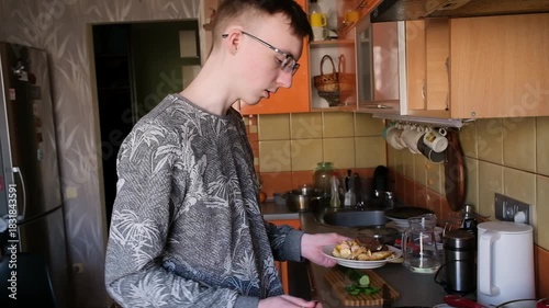 young man in the kitchen is preparing food for himself