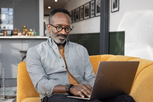 Focused Man Working on Laptop in Cozy Living Room