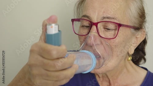 Senior woman inhaling medication from an asthma inhaler