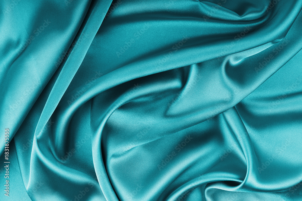 Fototapeta premium Crumpled, wrinkled turquoise colored glossy silk satin with wave drapery.. Shiny smooth fabric with soft folds, cloth texture . Elegant rich background, wallpaper, backdrop. Flat lay, top view