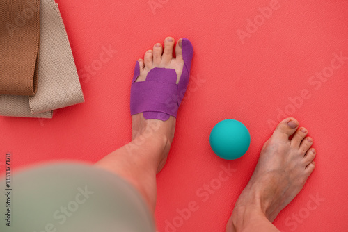 Woman foot with a kinesiology tape. Treatment for hallux valgus, sport pain. Top view.