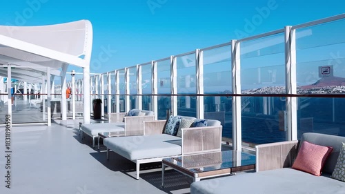 Open deck with cushioned seating glass railing bright sky clean surfaces minimal design and calm spacious atmosphere.