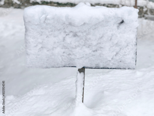 Snow covered signboard in deep winter snow outdoors
