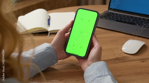 Woman use digital tech cell phone open green screen mock up. Hand press click phone web site middle center. Girl hold mobile. Turn on chroma key page. Cozy home background. Online app copy space.