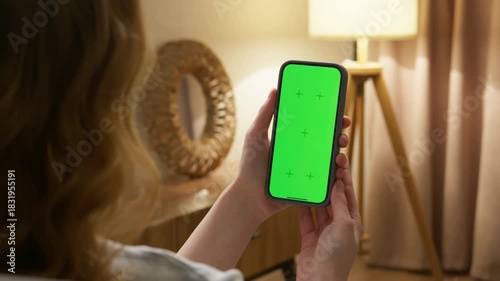 Woman use digital tech cell phone green screen mock up talk video call. Hand swipe click phone web site middle center. Girl hold mobile. Chroma key page. Cozy home background. Online app copy space.