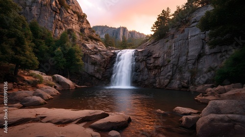 A majestic waterfall cascades down rugged cliffs into a serene pool illuminated by the soft glow of a twilight sky