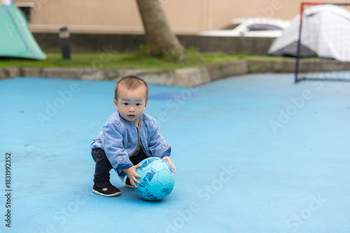 Little baby playing soccer outside