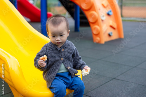 Baby eating snack at outdoor playground park