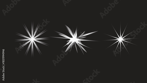 Three bright white light burst effects on a dark