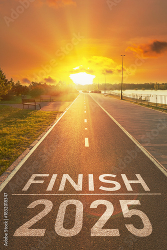 2025 year end concept. Motivational final inscription for to summary the year. Finish 2025 year is written on empty asphalt path in the bright rays of the sunset. Summing up the year background