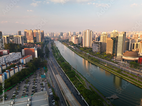 aerial view of Pinheiros river in Sao Paulo city with skyline in the distance during sunset