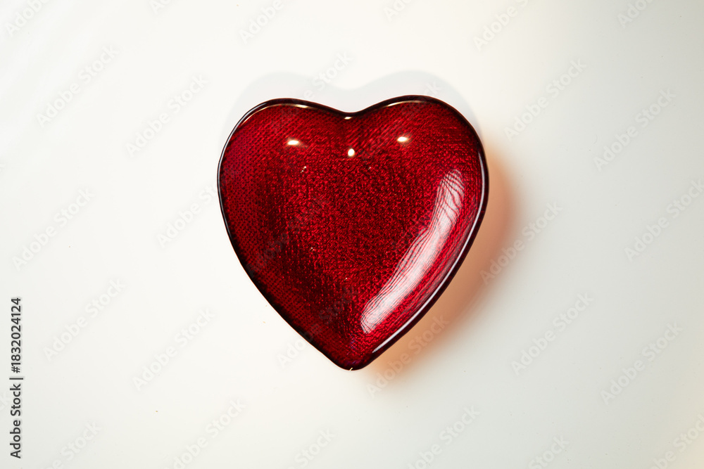 Obraz premium corazón de cristal rojo sobre superficie blanca