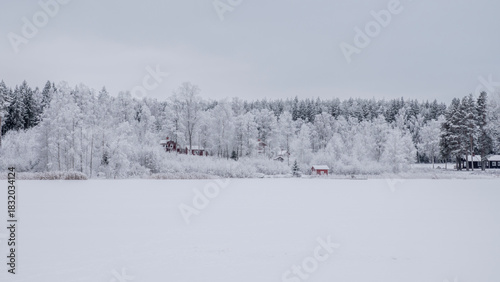 Farm barn and house in a cold and frosty morning in a wintry landscape
